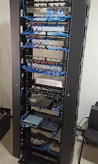 Rack de rede com patch panels, switches e cabeamento organizado