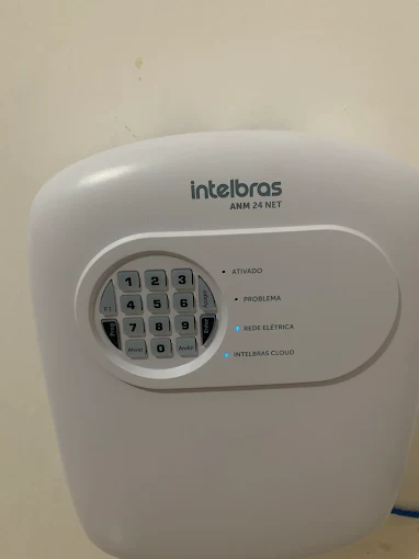 Central de alarme monitorado instalada na parede, com teclado e indicadores acesos
